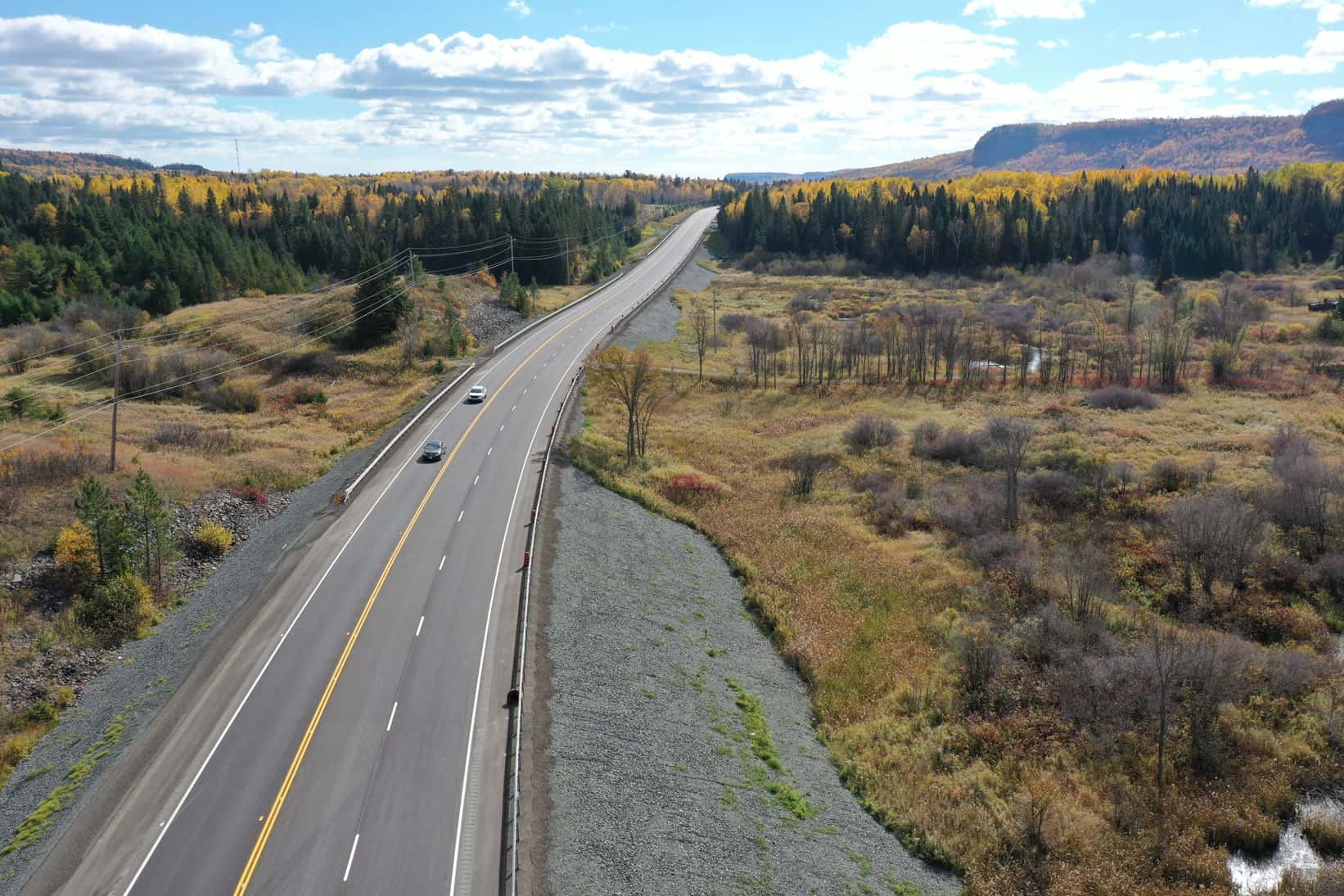 Let's hit the road! Motorists on a newly constructed highway—a project by LH North. Drone view.