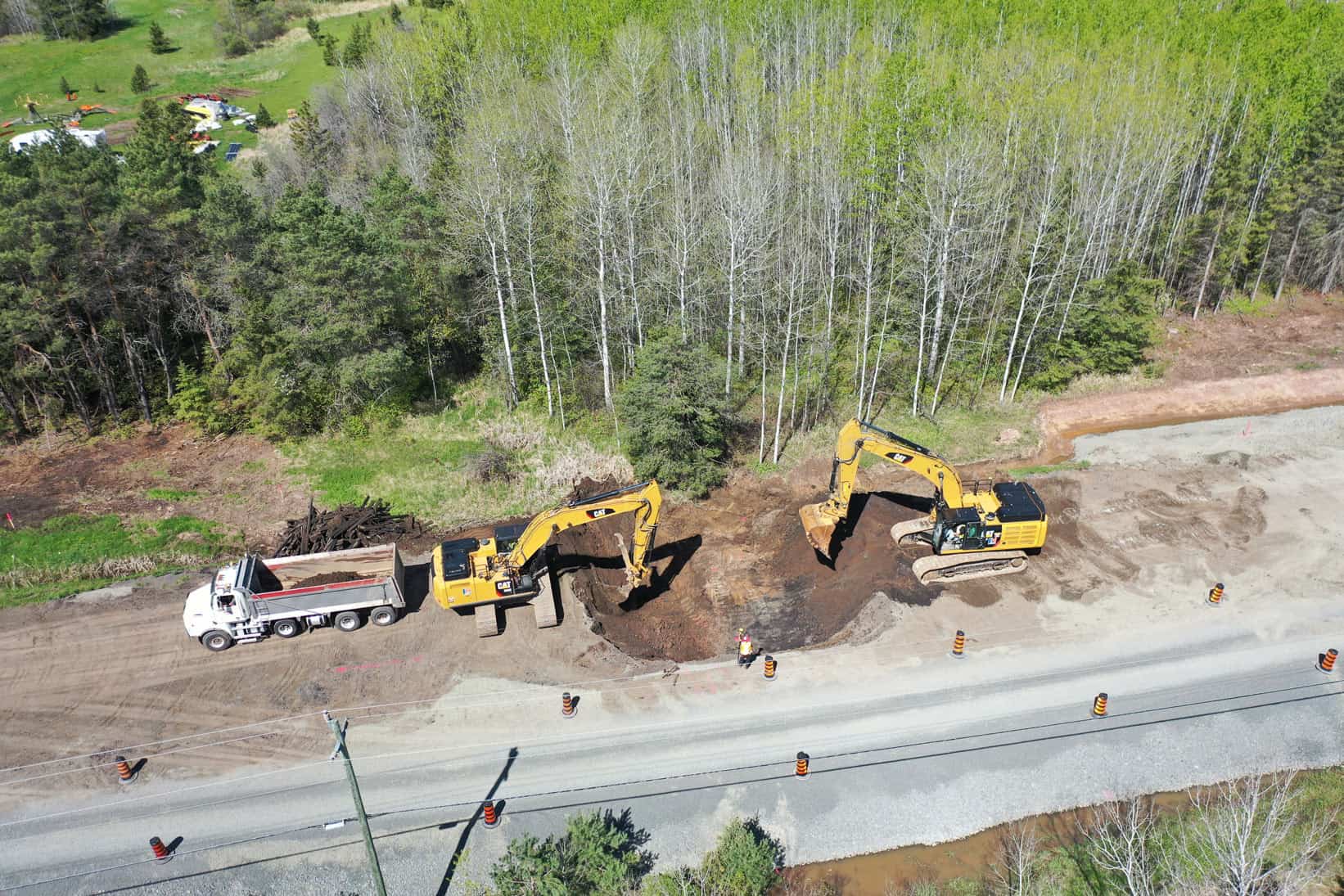 Let's dig a pit! Two LH North excavators play together in the sand at a highway reconstruction site. A bird's-eye view.