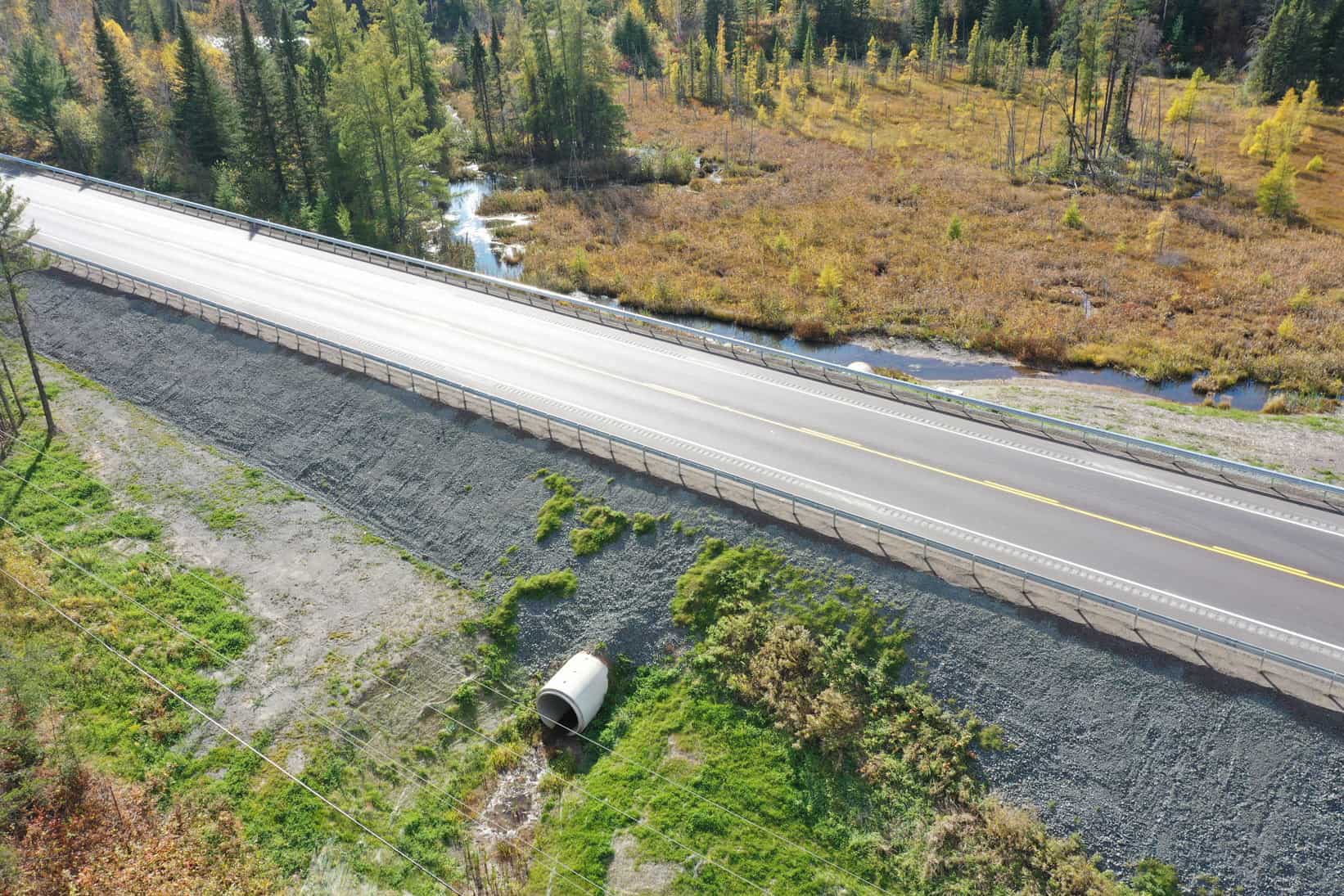 A newly constructed highway by LH North. Smart safety railings protect motorists, and an industrial water pipe will sort out overflow from the river in no time.